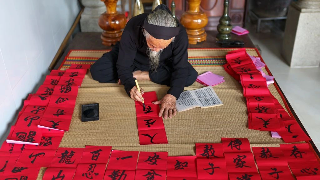 Elderly calligrapher at a low desk by paper-window light